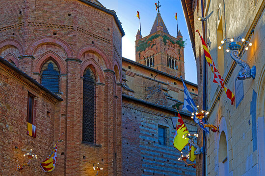 SIENA, ITALY, April 24, 2026 : San Clemente in Santa Maria dei Servi and a small street decorated with flags