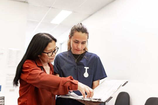 Medical staff collaborating in clinic with clipboard