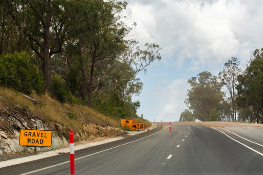 Gravel road sign warning of gravel ahead on highway