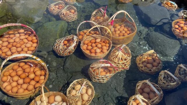 Boiling chicken and quail eggs in bamboo baskets at Chae Son hot spring, Lampang, Thailand