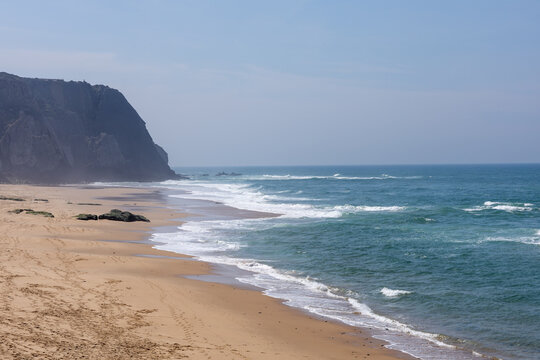 Sandy beach with ocean waves breaking on shore