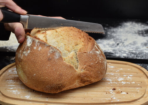 Cutting Rustic Bread Loaf with Bread Knife
