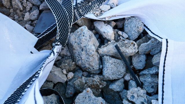Construction waste, debris and garbage discarded on a public city street. Renovation rubbish and industrial waste materials left outdoors on a sidewalk in urban area for recycling or dump
