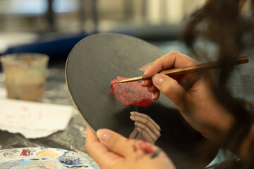 Obraz premium Artist hands painting red flower on canvas