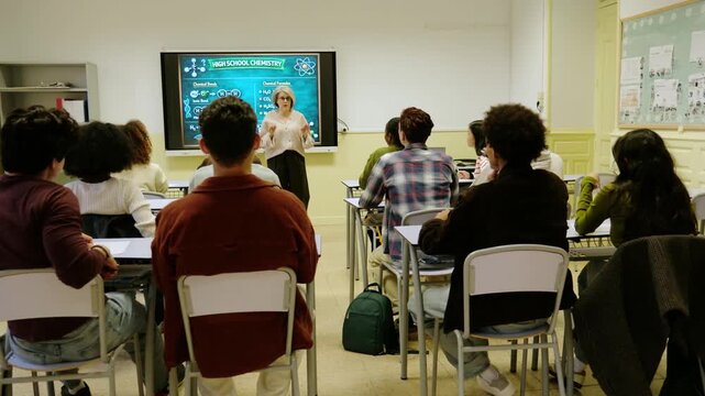 High school students enthusiastically raising their hands to answer a question in a chemistry lesson