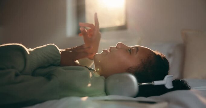Girl, singing or listening with headphones in bed for music, audio streaming or online subscription. Child, kid or lying with smile or flare in bedroom for podcast, sound app or song playlist in home