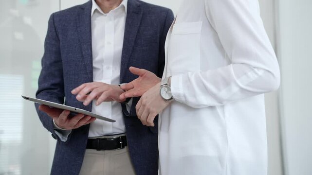 Business colleagues collaborating on an important project, discussing strategy and sharing ideas while working with a tablet in a modern office environment