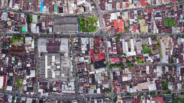 Aerial view of dense urban rooftops, narrow streets, and a small green park in the town of Kejajar, Central Java, Indonesia.