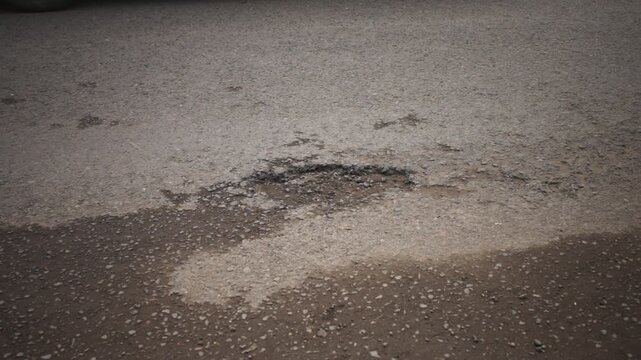 Close-Up of Road Pothole on Damaged Asphalt Street
