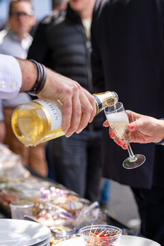 Service de champagne lors d&rsquo;un &eacute;v&eacute;nement festif en ext&eacute;rieur avec invit&eacute;s et ambiance conviviale.