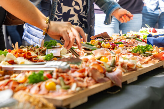 Buffet traiteur avec planches de charcuterie, fromages et tapas lors d&rsquo;un &eacute;v&eacute;nement convivial en ext&eacute;rieur.