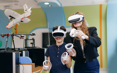 Boy and woman smiling with vr headsets in classroom, innovative education learning in engineering...
