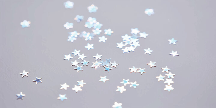 Scattered small star confetti on light gray surface with confetti scattered decoration celebration background abstract material metallic brightly isolated individual