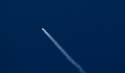 Fototapeta premium Concept aerospace program, Rocket launches into clear blue sky leaving white trail