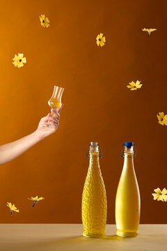 bottles of home made limonchello with hand raising a toast and yellow flowers