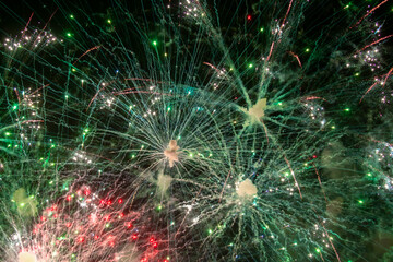 Fototapeta premium Fireworks close-up. Multicolored fireworks in the night sky, bright festive background with space for text.