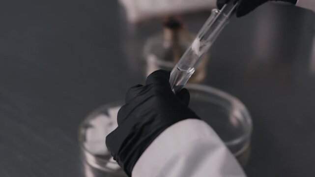 Laboratory technician handling test tube during scientific analysis close up
