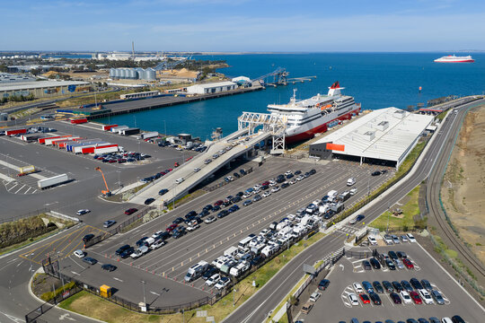 Aerial view of cars boarding a passenger ferry at a shipping terminal