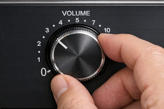 A person's hands adjusting the volume on a device, great for technology or everyday life scenes