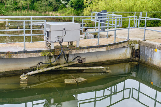Wieringerwerf, Netherlands - 17 May 2026: View of the Gemaal Leemans pumping station with metal railings and concrete structures surrounded by lush green trees.