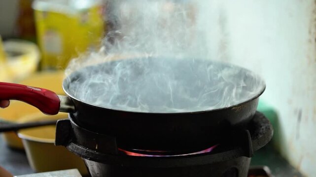 Cooking process - Boiling water in a pan over a gas stove flame.