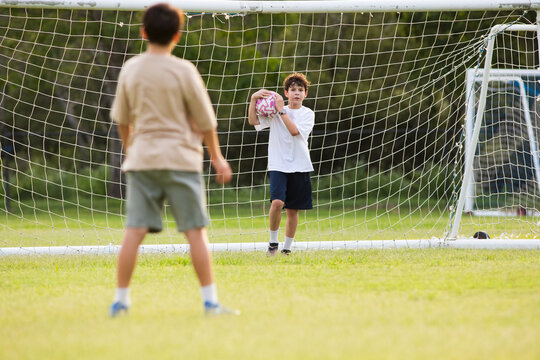 Young soccer player catches the ball during penalty kick