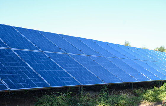 Closeup of solar panel rows installed on open field, photovoltaic solar panels for clean energy production, renewable energy farm in outdoor rural environment, solar power technology