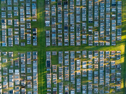 Overhead top down view of neat rows of graves in cemetery from aerial view