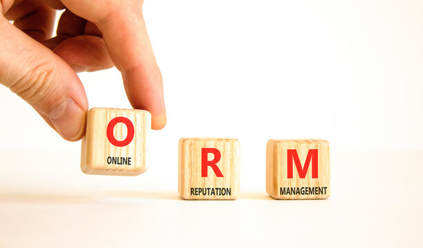 ORM online reputation management symbol. Concept words ORM online reputation management on beautiful wooden blocks. Businessman hand. Beautiful white background. Business ORM concept. Copy space.