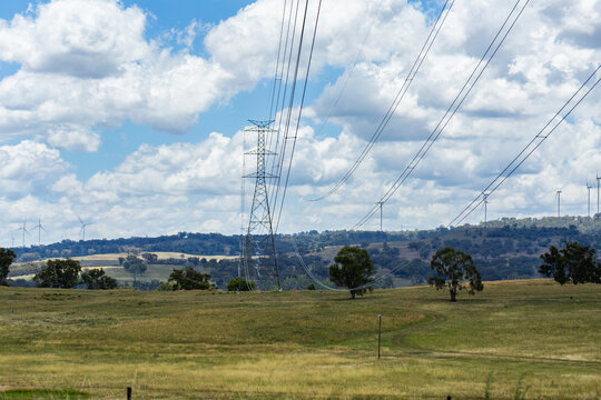 Transmission towers (electrical pylons) and powerline in front of wind turbine generators