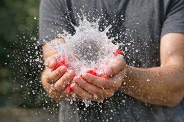 Fototapeta premium A person holds a small amount of water in their hand, ready to use
