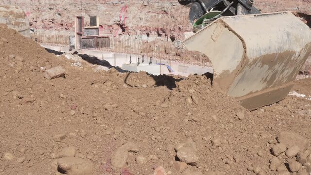 Heavy machinery excavator grading and leveling soil earth at an infrastructure development site, professional engineering and building construction zone