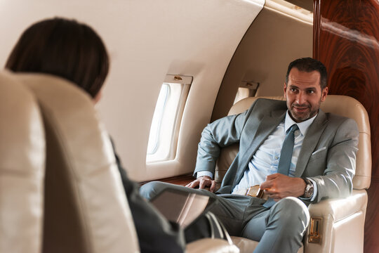 Business executive in a private jet having a relaxed conversation during an in-flight meeting
