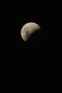 Partial lunar eclipse showing the moon being obscured by Earth's shadow in the night sky