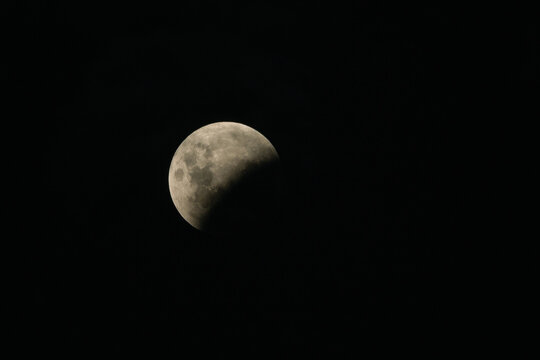 Lunar eclipse in progress showing the moon partially obscured by Earth's shadow in the night sky