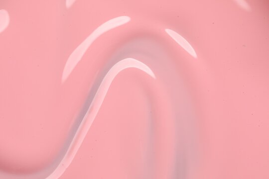 Pink nail polish as background, top view