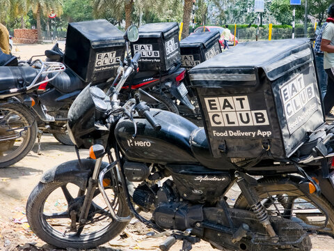 Delhi, India - 26th Apr'26: Branded Eat Club food delivery bags mounted on motorcycles parked outdoors, food delivery services startups competing with Zomato and Swiggy