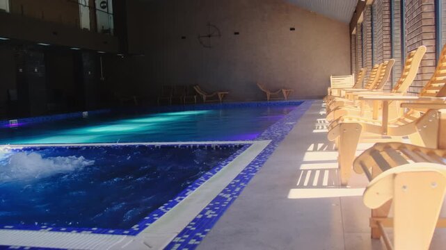 Therapeutic bath with clear spouting water at luxury spa resort poolside. Modern swimming pool and bubble massage tub at hotel. Luxury lifestyle
