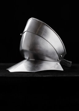 Steel gorget photographed on black velvet background. Clean lines and polished surface reflect studio lighting.