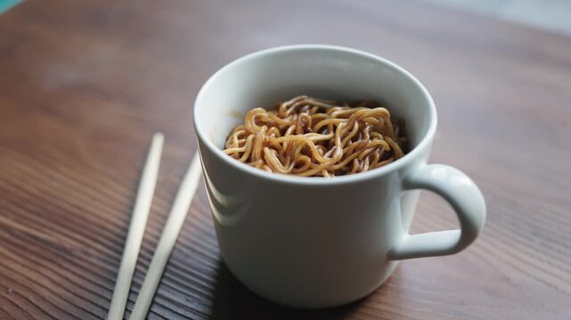 Close-up of instant noodles with hot water in a white cup