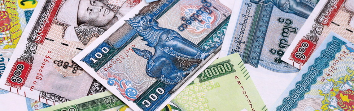 Myanmar kyat money bills pile on table. Myanmar banknotes of MMK currency close up.