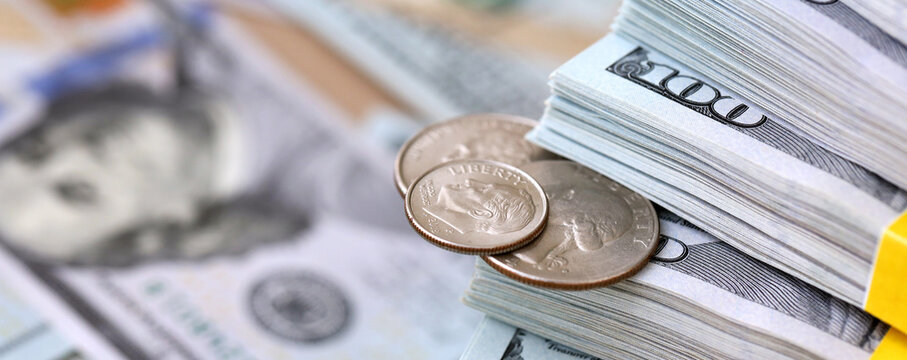 US coin lies among ten thousand dollars packs in stack on big amount of hundred dollar bills
