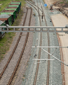 Vertical perspective view comparing old railway track and newly rebuilt rail line with fresh ballast, concrete sleepers and freight wagons during railway modernization.