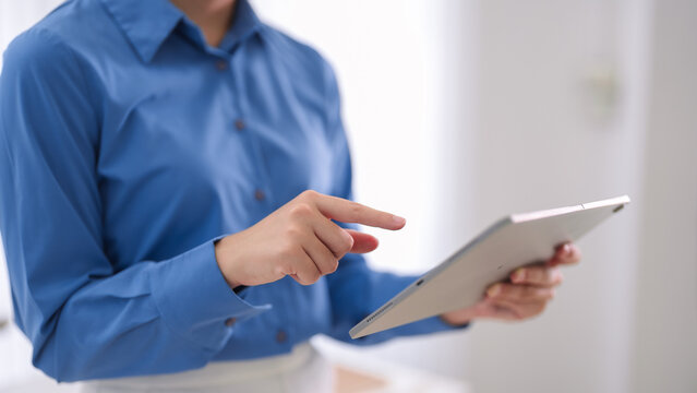 business professional using digital tablet touchscreen technology reviewing data report working modern office environment corporate workplace productivity