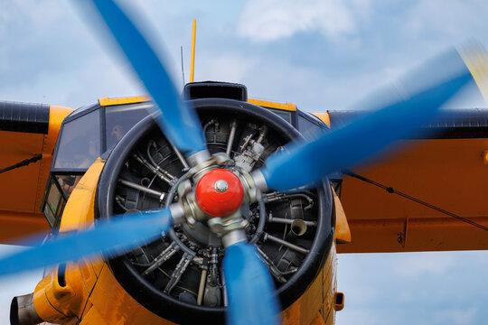 Close up of a vintage Antonov An-2 biplane radial engine and spinning blue propeller with motion blur