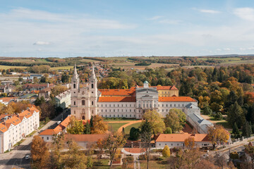 Fototapeta premium Aerial view of the historic Cistercian Abbey of Zirc and the monastery buildings surrounded by fall foliage.