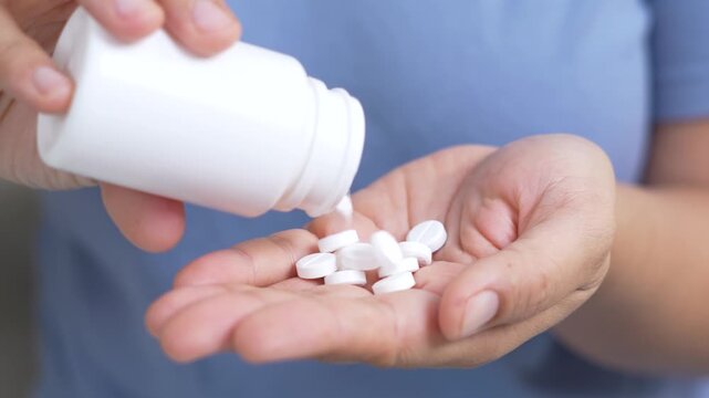 woman is holding headache pills to reduce her fever.