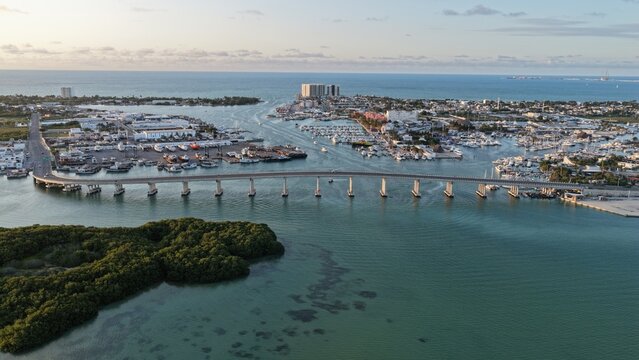 Aerial view of the Yucalpeten bridge and harbor with boats docked in the marina and lush mangroves in the foreground in Progreso, Yucatan, Mexico.