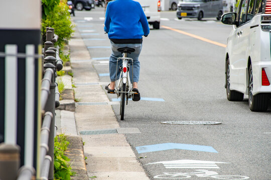 自転車ナビラインを走る自転車と横を追い越す自動車