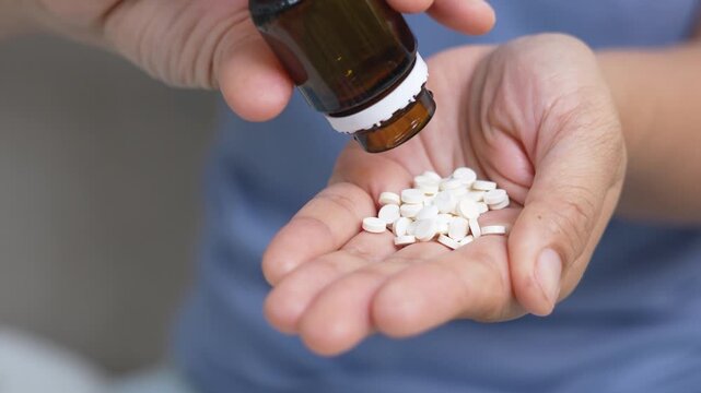 woman is holding headache pills to reduce her fever.